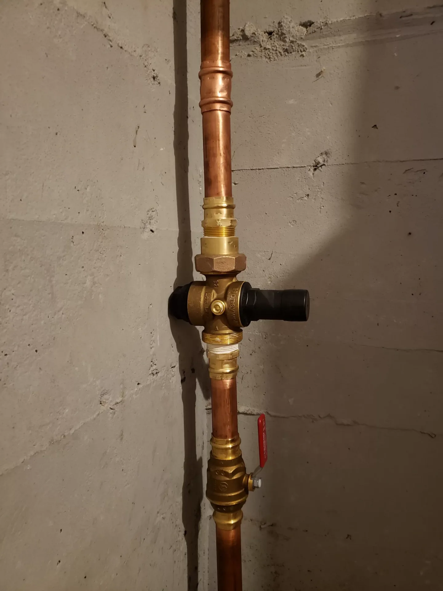 Copper water pipe and valve in a basement.